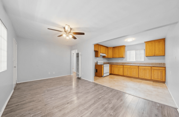 A room with a ceiling fan and wooden flooring.